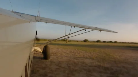 Plane side view starting engine next to runway in morning Stock Footage 310971867