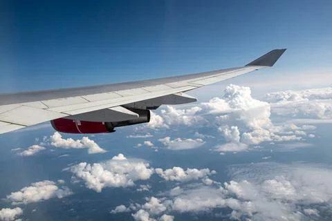 Plane silver wing during a flight over white clouds and a winter land is on t Foto stock