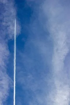 Plane in the sky with cloud trail and clouds semi clear sky Foto stock