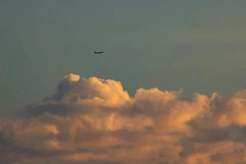 Plane in the sky at sunset Stock Photos