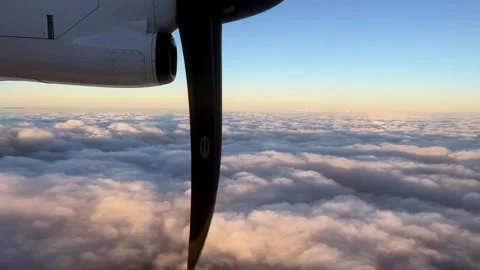 A plane soaring through cumulus clouds in the sunset sky Stock Footage 281519554