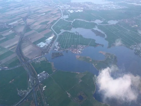 Plane soars over the clouds, lakes and flat lands of Holland (4K) Stock-Footage 79796398