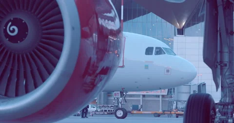 The plane is standing next to the airport building, the red turbine rotates Stock Footage 119590971