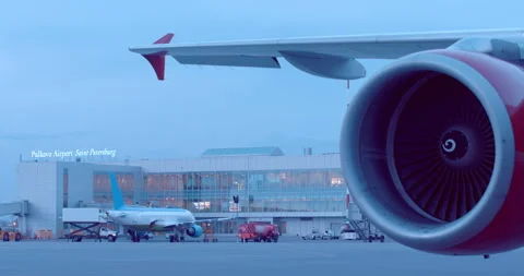 The plane is standing next to the airport building, the red turbine rotates Stock Footage 119592111