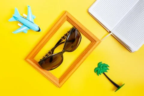 Plane, sun glasses, notebook and palm on yellow background, flat lay - travel Stock Photos