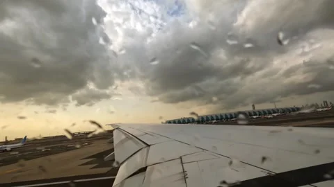 Plane takeoff, wing view of emirates flight from Dubai to Seychelles, rainy day Stock Footage 324842529