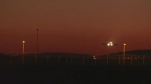 Plane takes off at night passing overhead as it ascends into the night sky Stock Footage