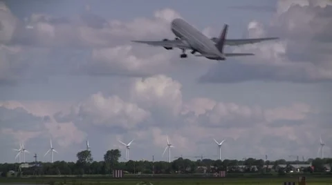 Plane takes off, windturbines in the background Stock Footage 7732970