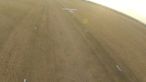 Plane taking off from a grassy airstrip, showcasing the gradual ascent into the Stock Footage 328159152