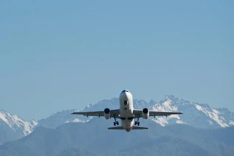 Plane Taking Off over Snowy Mountains and Blue Sky Stock-Fotos