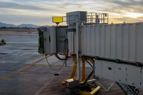 Plane taking off into red sunset in boarding bridge used connect airport Fotos Stock