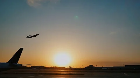 Plane taking off sky sunset sun dusk in airport China. Beijing. Stock Footage
