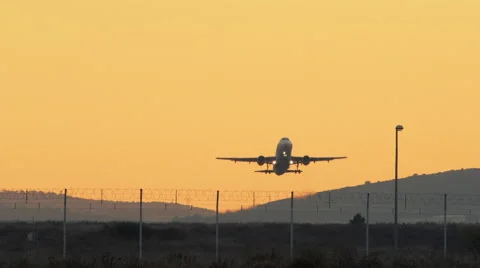 Plane taking off into the sunset sky ascends passing overhead Vidéo 45391781