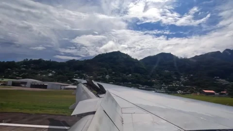 Plane touch down on Mahe island, wing view of emirates flight from Dubai to Stock Footage 324890181