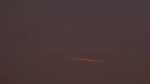 Plane trail at sunset red light Stock Footage 164676375