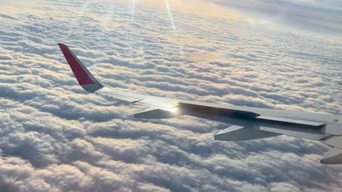 The plane turns over the clouds, in the rays of the sun. View of the wing of the 스톡 동영상 170757980