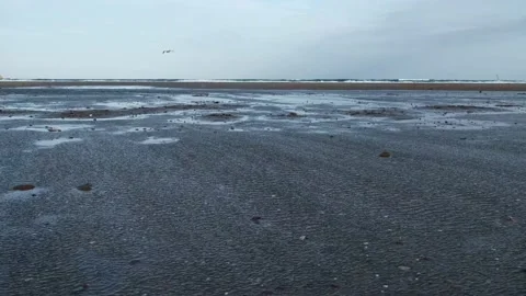 Plane of the wind hitting the puddles on the seashore and in the background a bi 库存影片 232952833