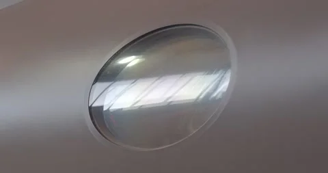 Plane window reflection. Closeup of aircraft window reflecting lights Stockbeeldmateriaal 333891399
