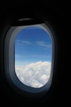 Plane window view with blue sky and sea Stock Photos