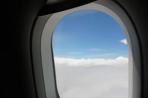Plane window view with blue sky and sea Stock Photos