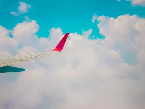 Plane window view - View of beautiful clouds and wing of airplane from window Stock Photos