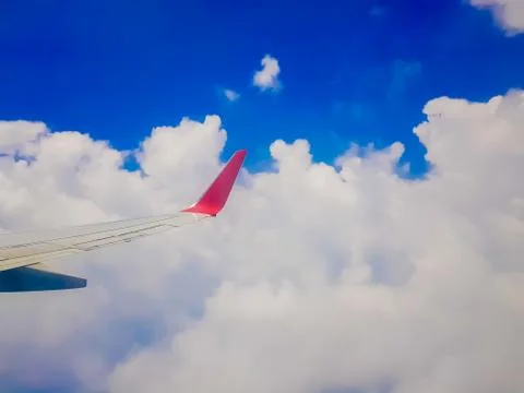 Plane window view - View of beautiful clouds and wing of airplane from window Stock Photos