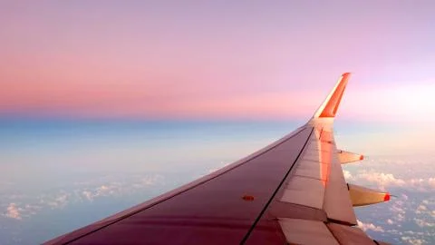 Plane wing, cloud and gradient pink to blue sky, Stock Photos