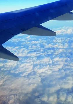 Plane wing with clouds Stock Photos
