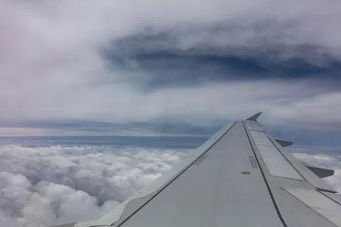 Plane wing on cloudy sky background. View out of an airplane window. Foto stock