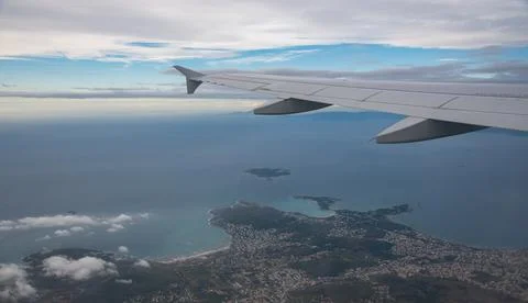 Plane wing in a flight and dramatic cloudscape white clouds over europe Photos
