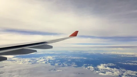 Plane wing at flight through white clouds, fair weather, blue sky Видео 74986040