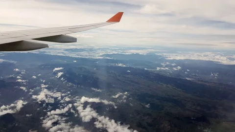Plane wing at flight, white clouds above mountains, fair weather, blue sky Vídeos de archivo 74986543
