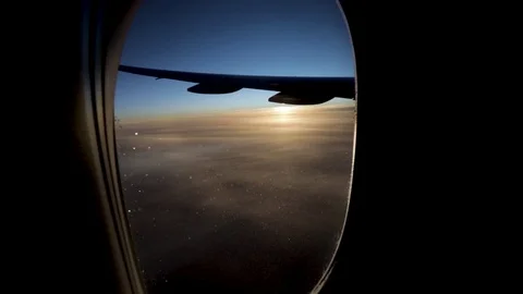Plane wing trough a window with a sunrise in background. 스톡 동영상 102868413