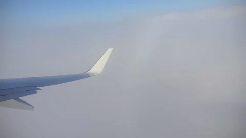 A plane wing in view above the clouds during flight in 4K slow motion 120fps Stock Footage 285882832