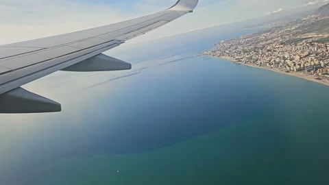 Plane wing view while fly over sea after take off,airliner transport 4k 스톡 동영상 345131034