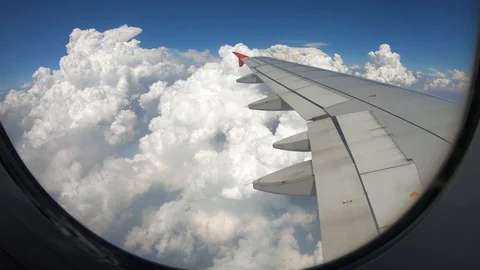The plane wings while flying in the sky with beautiful white clouds floating. Видео 116472484