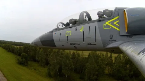 Plane with yellow fuselage elements flies very quickly and low above the ground. Stock Footage 118676993