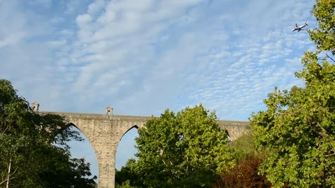 Planes flying really close to city centre, frame with ancient roman aqueduct in Stock Footage 118666888