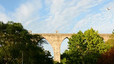 Planes flying really close to city centre, frame with ancient roman aqueduct in Stock Footage 118666905