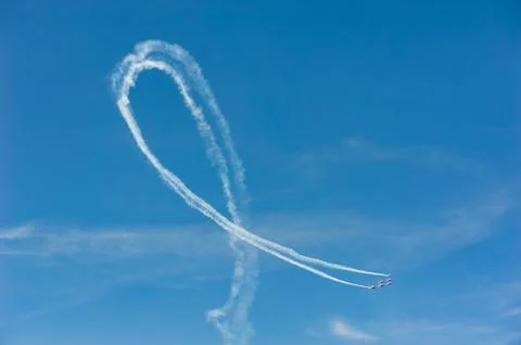 Planes in formation doing a loop with white smoke trail in blue Stock Photos