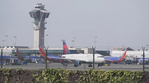 Planes moving around next to tower at LAX airport Stock Footage 89186705