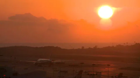 Planes taxi at sunset or sunrise at a major metropolitan airport. Stock Footage