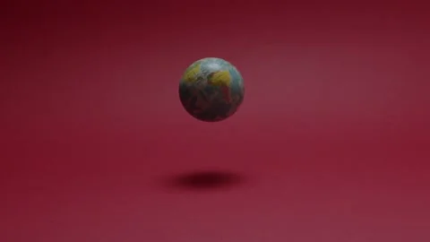 Planet ball falling to a red background in slow motion Stock Footage 198372281