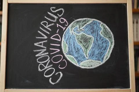 Planet Earth in danger Outbreak Warning. written white chalk on blackboard in Foto stock