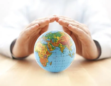Planet Earth globe protected by hands. Stock Photos