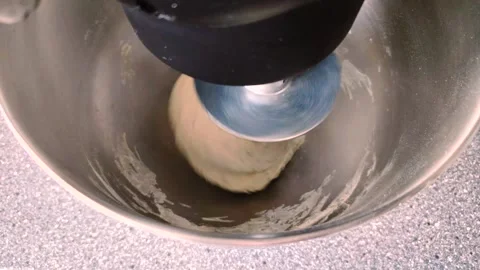 Planetary mixer kneading bread dough with a spiral hook in a metal bowl. Stock Footage 333756679