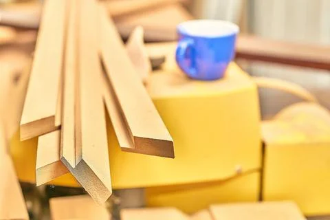 Planks, boards in a carpentry workshop and a blue cup Stock Photos