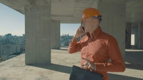 Planner engineer with a briefcase on the building under construction Stock Footage 76539890