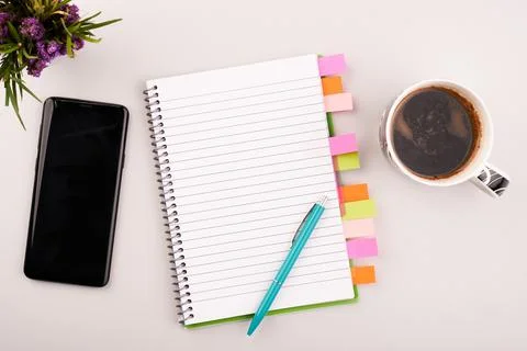 Planner on the grey working table with phone and coffee. Blank white paper on Stock Photos