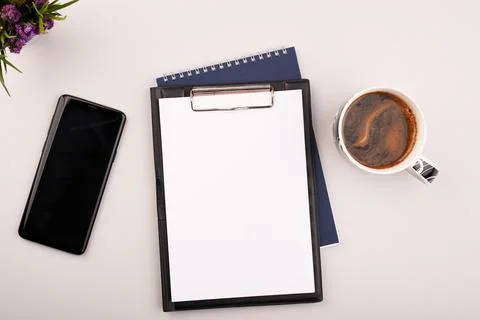 Planner on the grey working table with phone and coffee. Blank white paper on Stock Photos